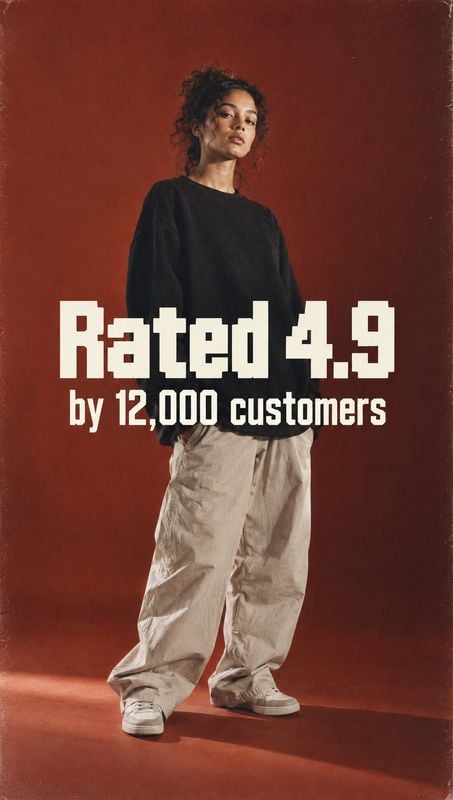 casual outfit black friday product photo: A model in a black top, loose beige trousers and sneakers poses against a deep rust studio backdrop, with bold cream…