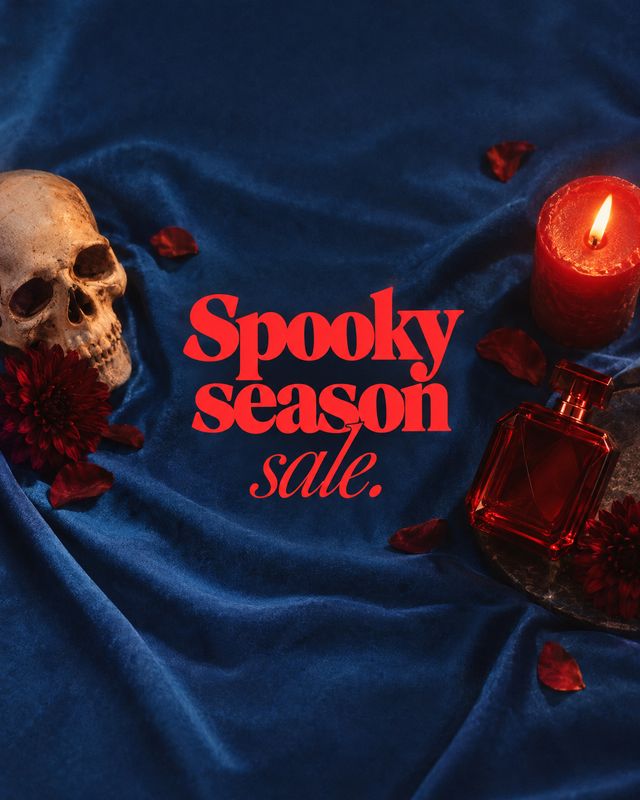 perfume halloween product photo: A red perfume bottle, lit candle, skull and scattered petals sit on deep blue velvet around bold red “Spooky season sale” lett…