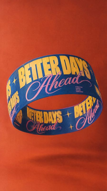 printed wristband floating product product photo: A blue printed wristband floats against a vivid orange studio backdrop, with oversized yellow and pink letter…