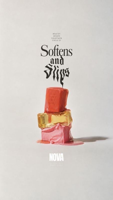 beauty product bottle close-up detail product photo: A vivid red, amber, and pink beauty product is stacked amid glossy melting textures on a pale studio backd…