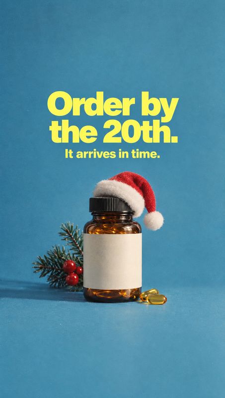 supplement bottle personal care product photo: An amber supplement bottle topped with a Santa hat sits beside capsules and a sprig of festive greenery against…