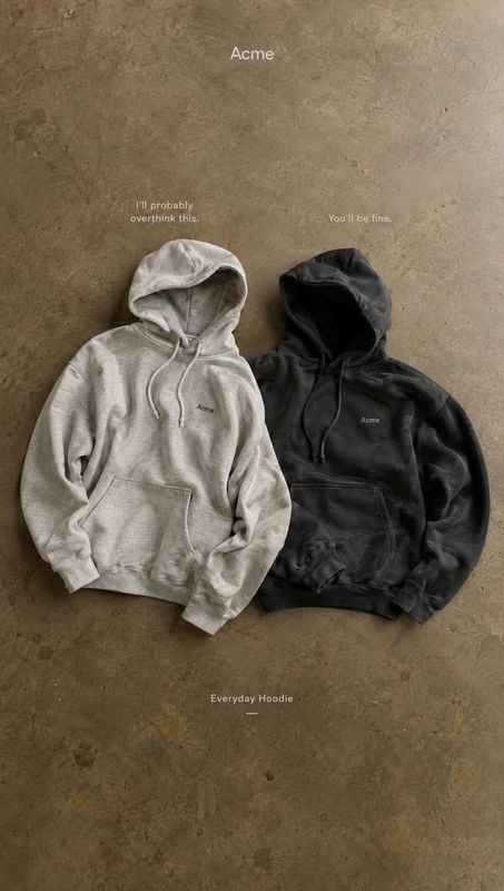 hoodies group lineup product photo: Two neutral-toned hoodies are arranged side by side on a textured concrete surface, with small white typography and soft, s…