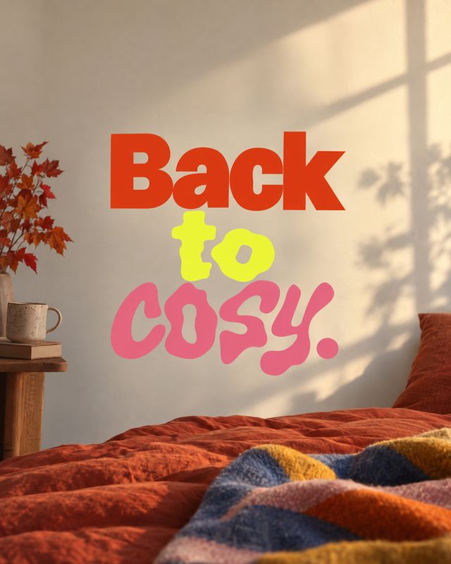 bedding autumn product photo: A warmly sunlit bedroom with rust-colored bedding, autumn leaves, and a cozy throw, styled with bold colorful “Back to cozy.” typ…