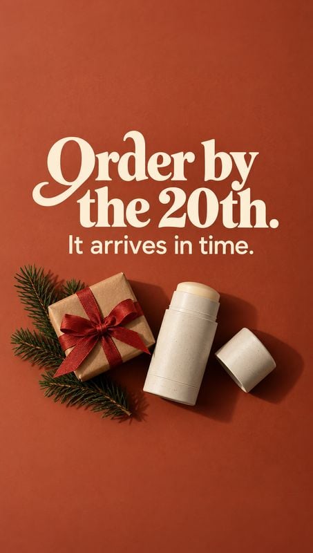 deodorant stick personal care product photo: A white deodorant stick and wrapped gift rest on evergreen sprigs against a warm terracotta backdrop, beneath bold…