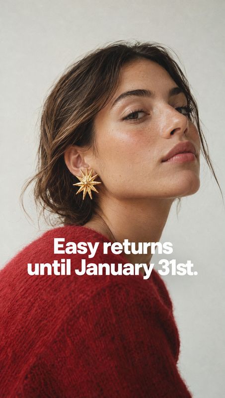 starburst earrings on-body detail product photo: A close-up portrait of a woman wearing gold starburst earrings and a red knit sweater against a pale studio ba…