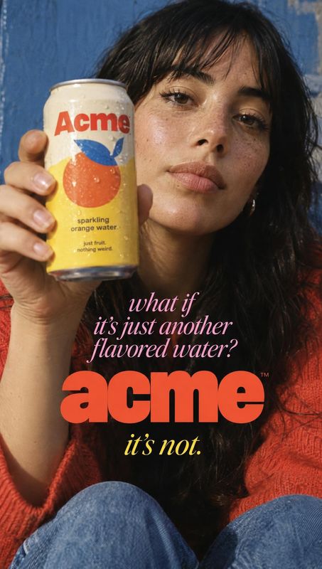 sparkling orange water can food and drink product photo: A woman in a red knit sweater holds a can of sparkling orange water close to the camera against a blue…