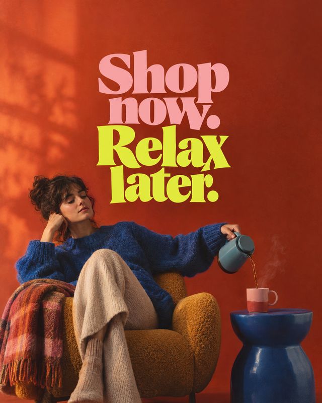 teapot lifestyle scene product photo: A woman in a blue sweater relaxes in a warm-toned armchair while pouring from a teapot, beneath bold pink and yellow lett…