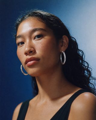 a close up of a person wearing large hoop earrings