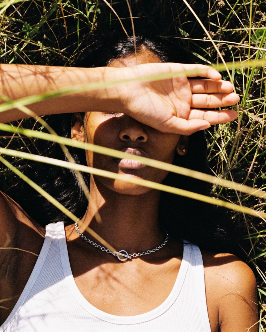 Woman in natural sunlight with complex shadows illustrating the challenge of balancing warm and cool tones in brand-color photography