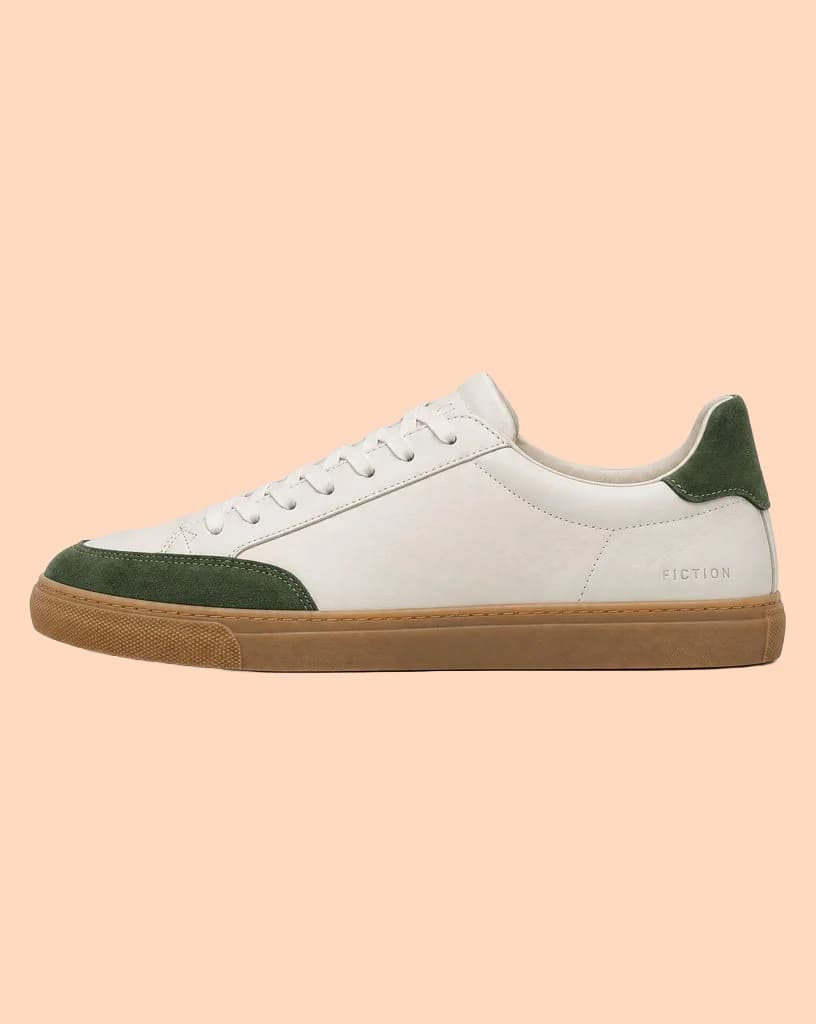 White leather sneaker with green suede panels on a warm gray backdrop, and the same sneaker on a flat peach background - After