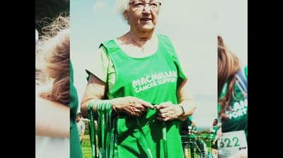 a woman in a green shirt is holding a frisbee