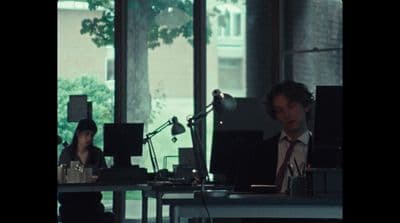 a man and a woman sitting at a table in front of a microphone