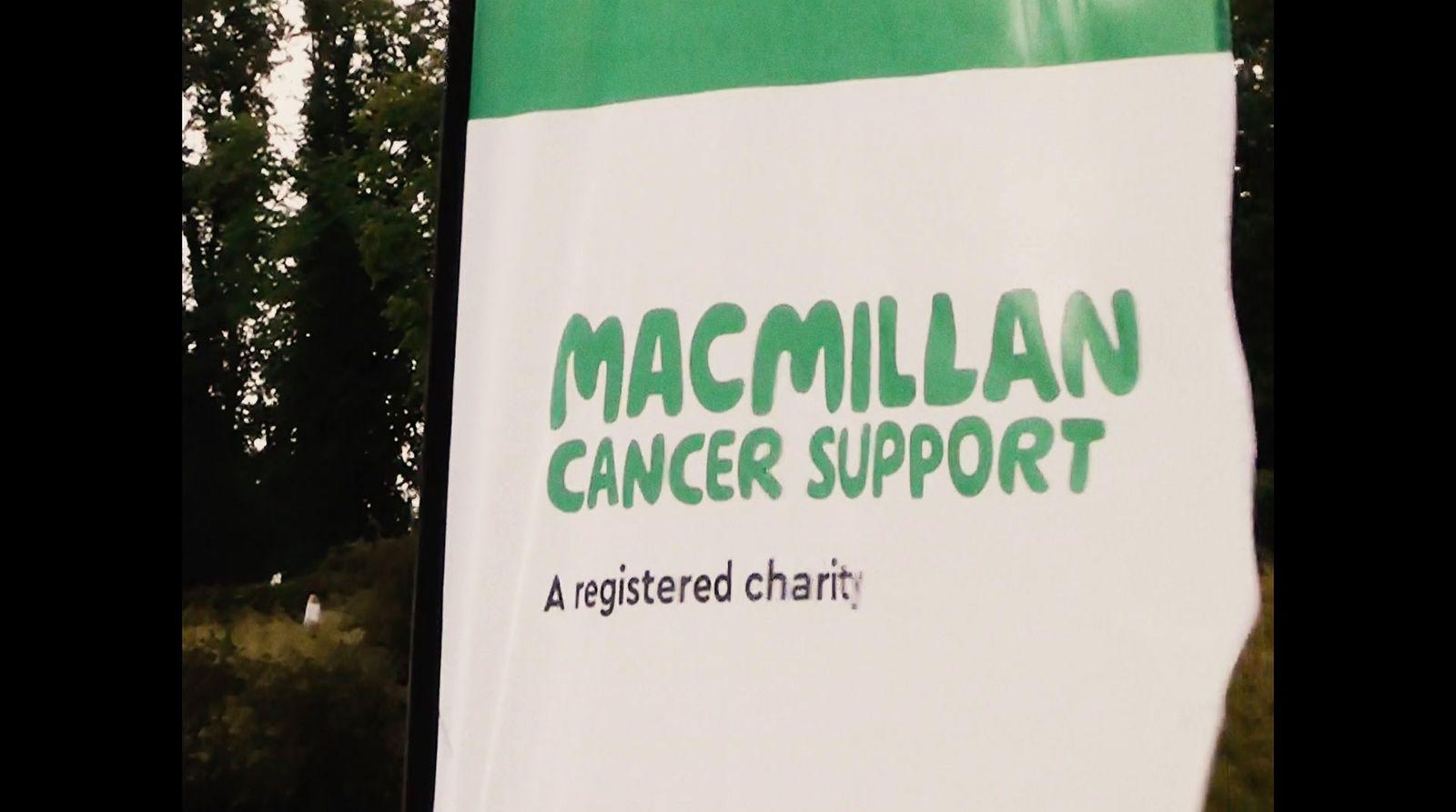 a green and white sign that says macmillan cancer support