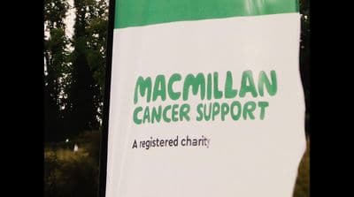 a green and white sign that says macmillan cancer support