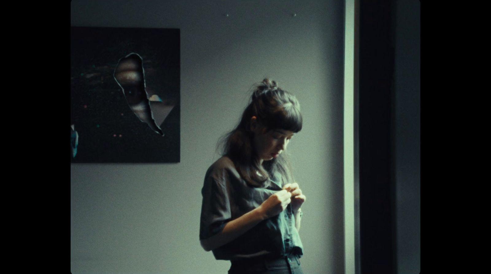 a woman standing in front of a window looking at her cell phone