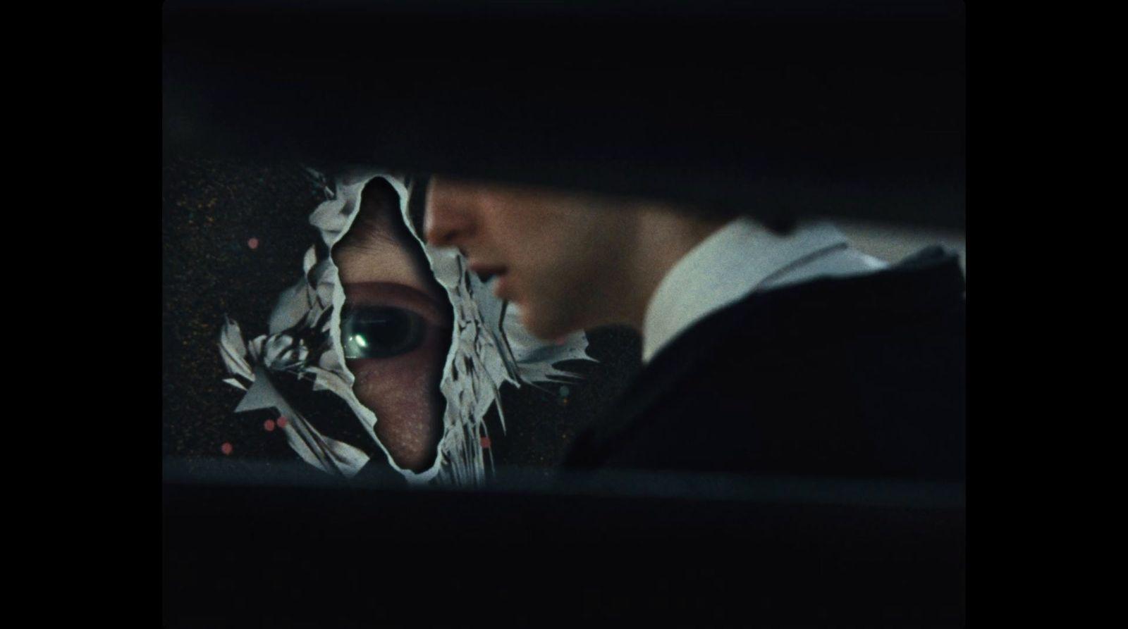 a man and a woman looking at each other through a hole in a piece of