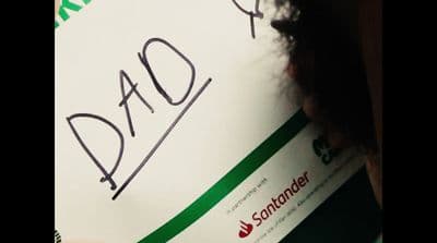 a close up of a person holding a sign with writing on it
