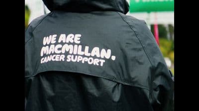 a person wearing a black jacket with white writing on it