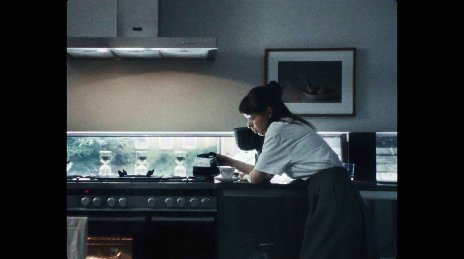 a woman standing in a kitchen preparing food