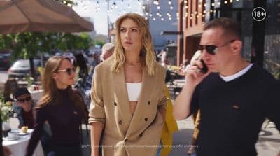 a woman talking on a cell phone while standing next to a man
