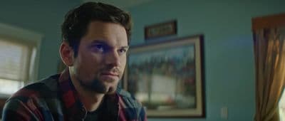 a man in a plaid shirt looking at the camera