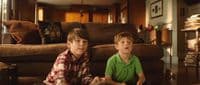 two young boys sitting on the floor in a living room
