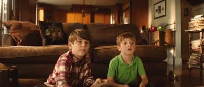 two young boys sitting on the floor in a living room