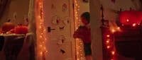 a person standing in front of a door decorated with lights