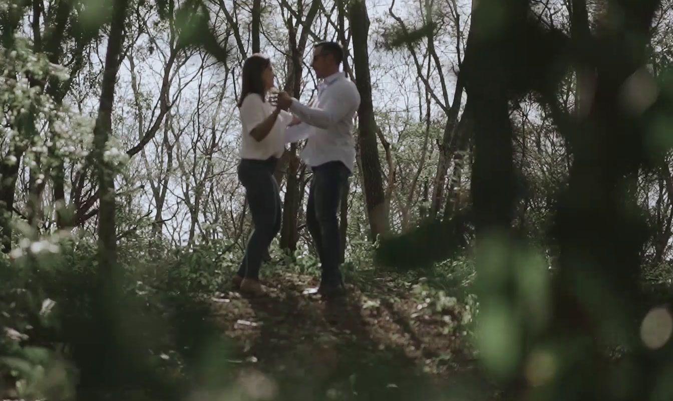 a man and a woman standing in the woods