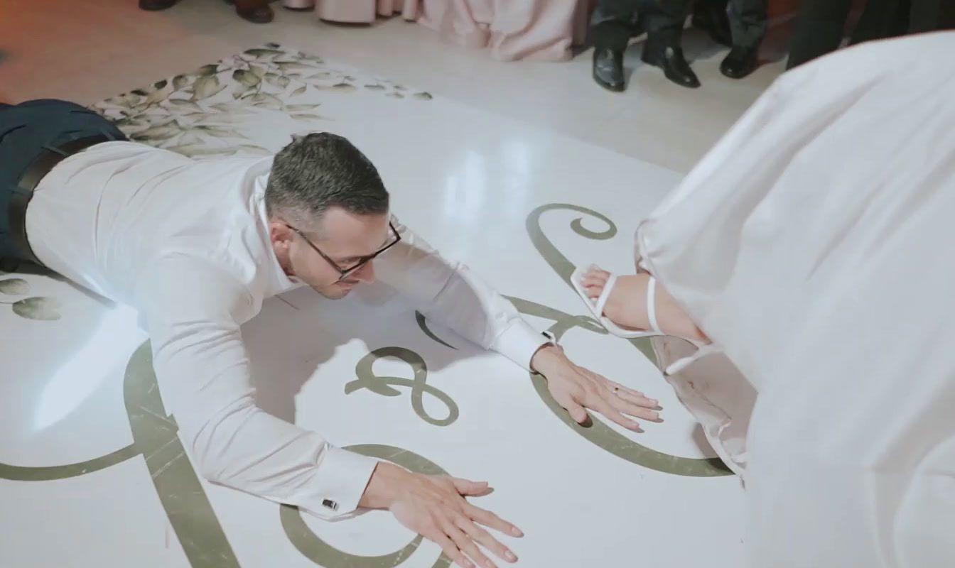 a man in a white suit and tie laying on the floor
