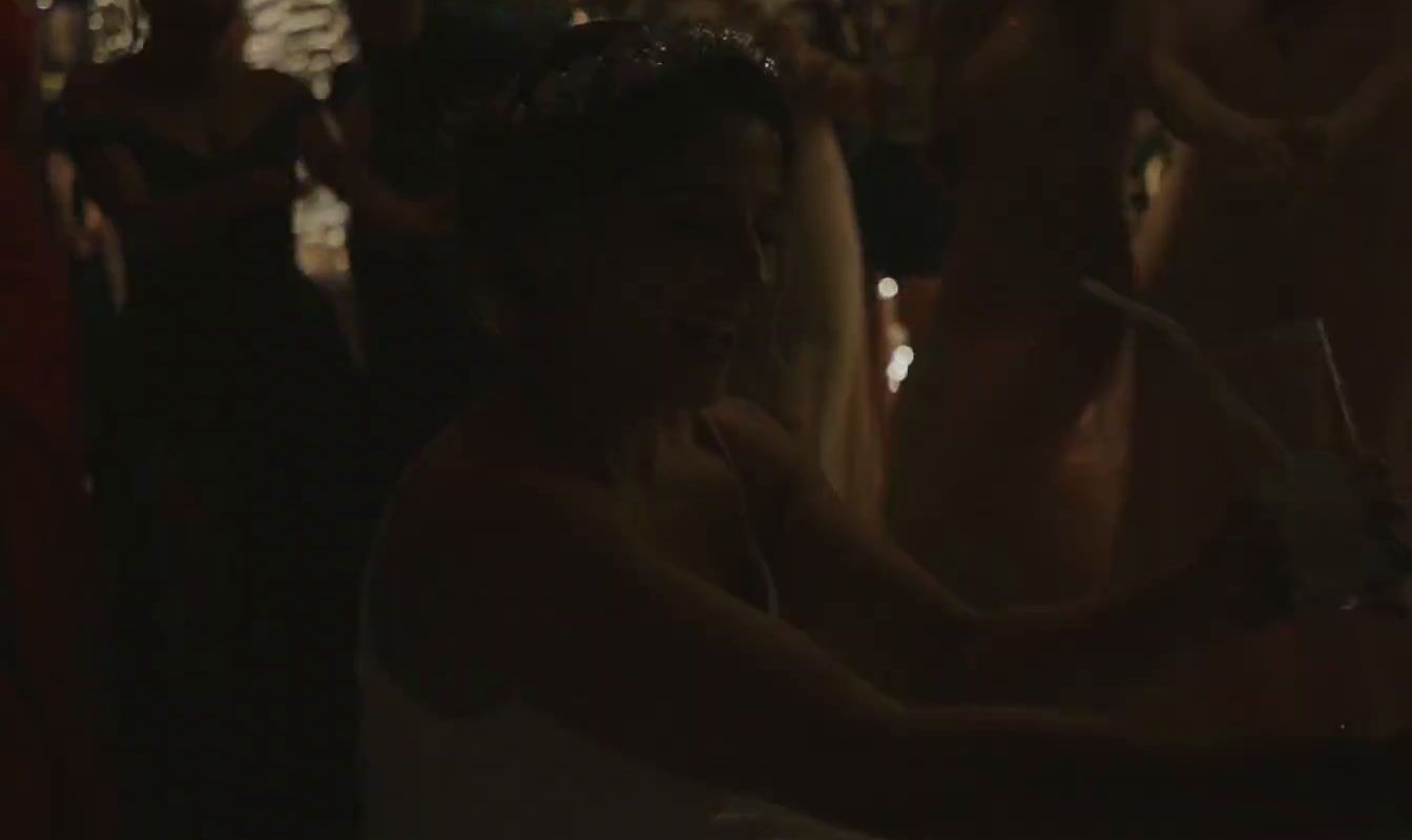 a woman in a white dress standing in front of a crowd