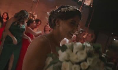 a woman in a red dress standing next to a bouquet of flowers