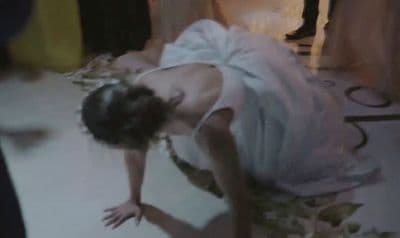 a woman in a white dress bending over on the floor