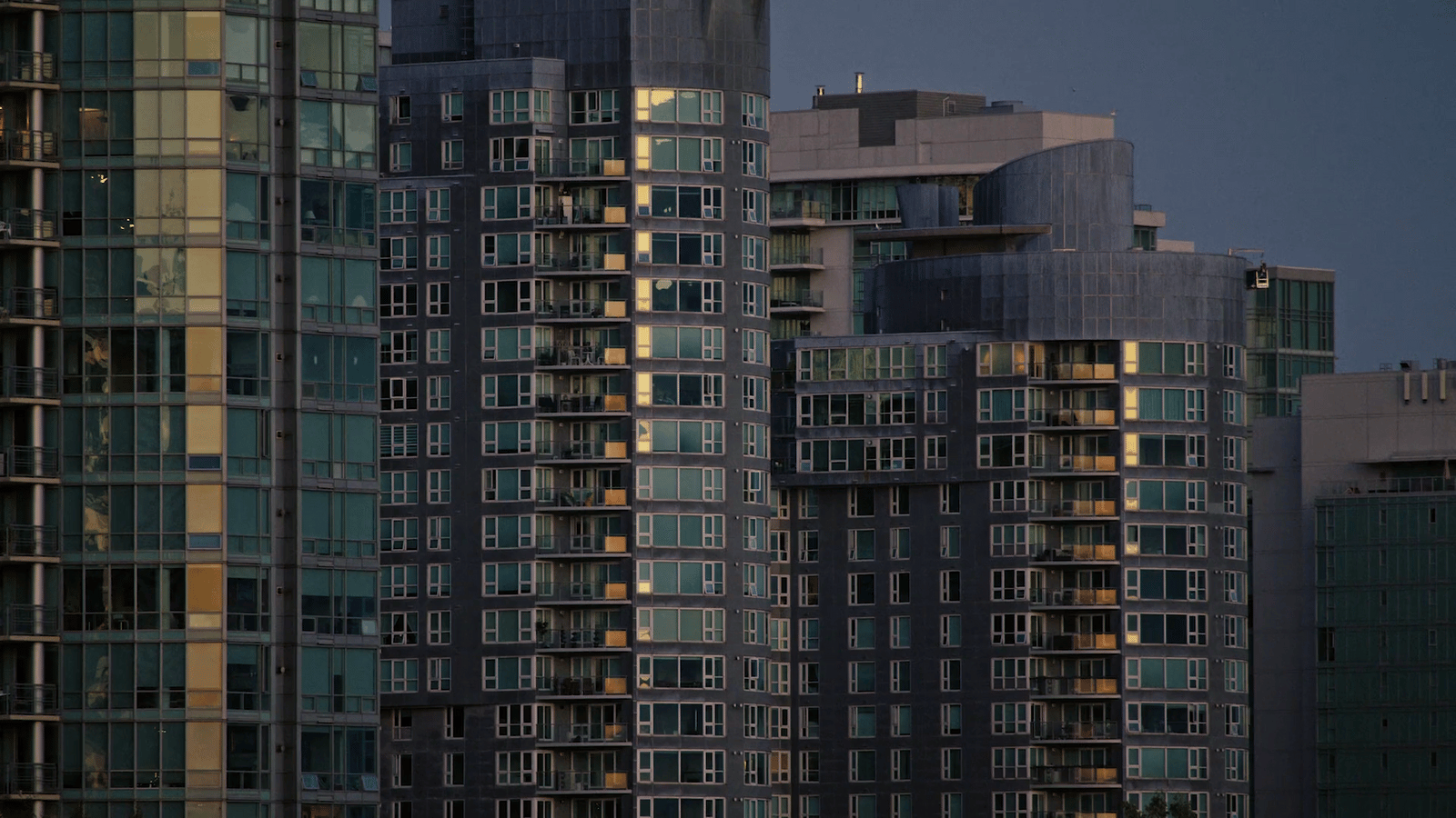 a plane is flying in front of some tall buildings