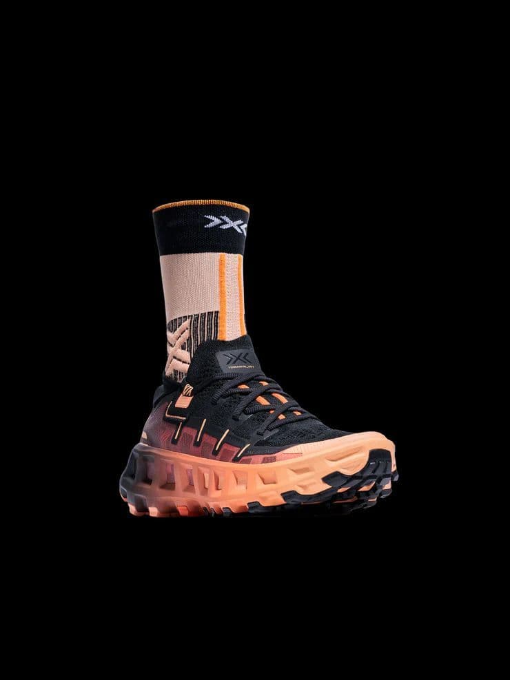 a pair of black and orange sneakers on a black background