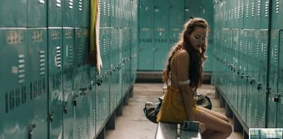 a woman sitting on a bench in a locker