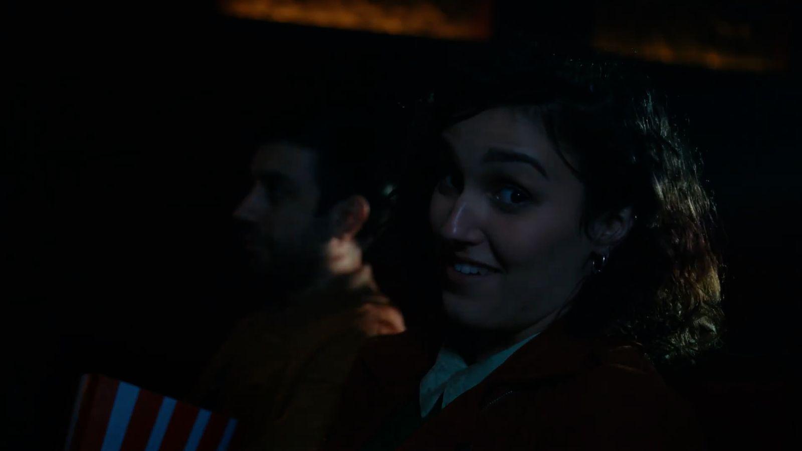 a man and a woman standing in a dark room