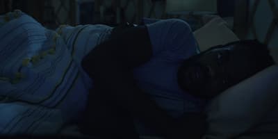 a man laying on a bed in a dark room
