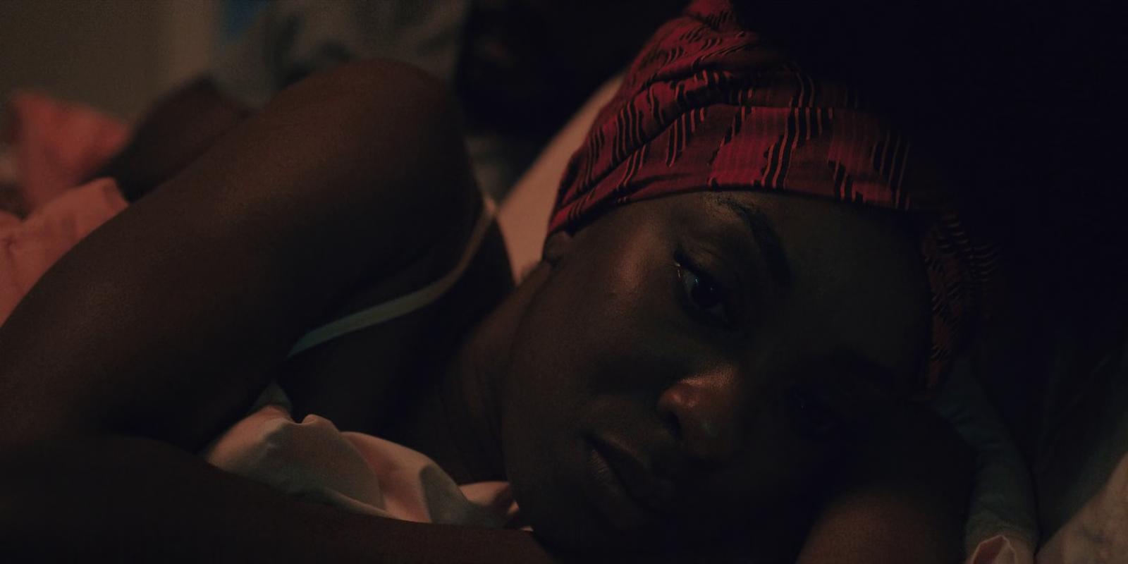 a woman laying in bed with a red headband