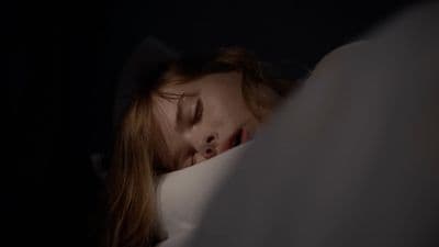 a woman is sleeping in bed with her eyes closed