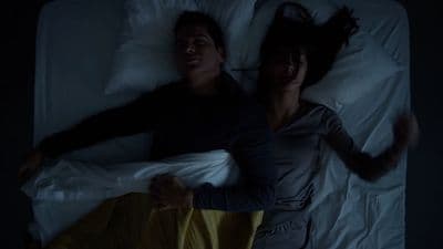 a man and a woman laying in bed together