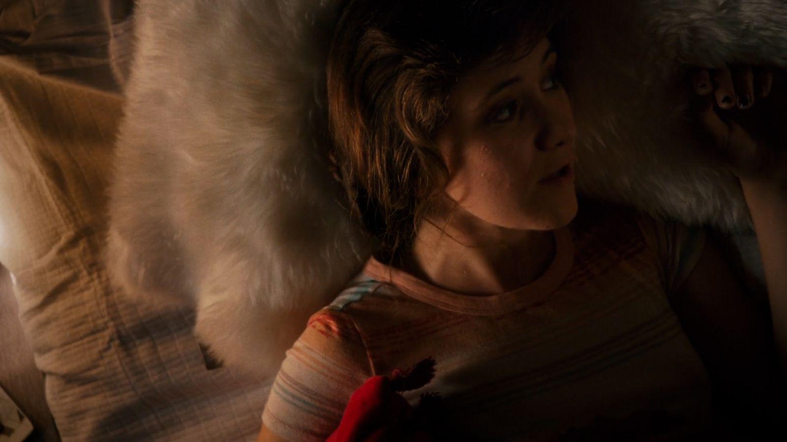 a woman laying on top of a bed covered in fur