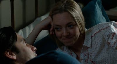 a woman laying on a bed next to a man