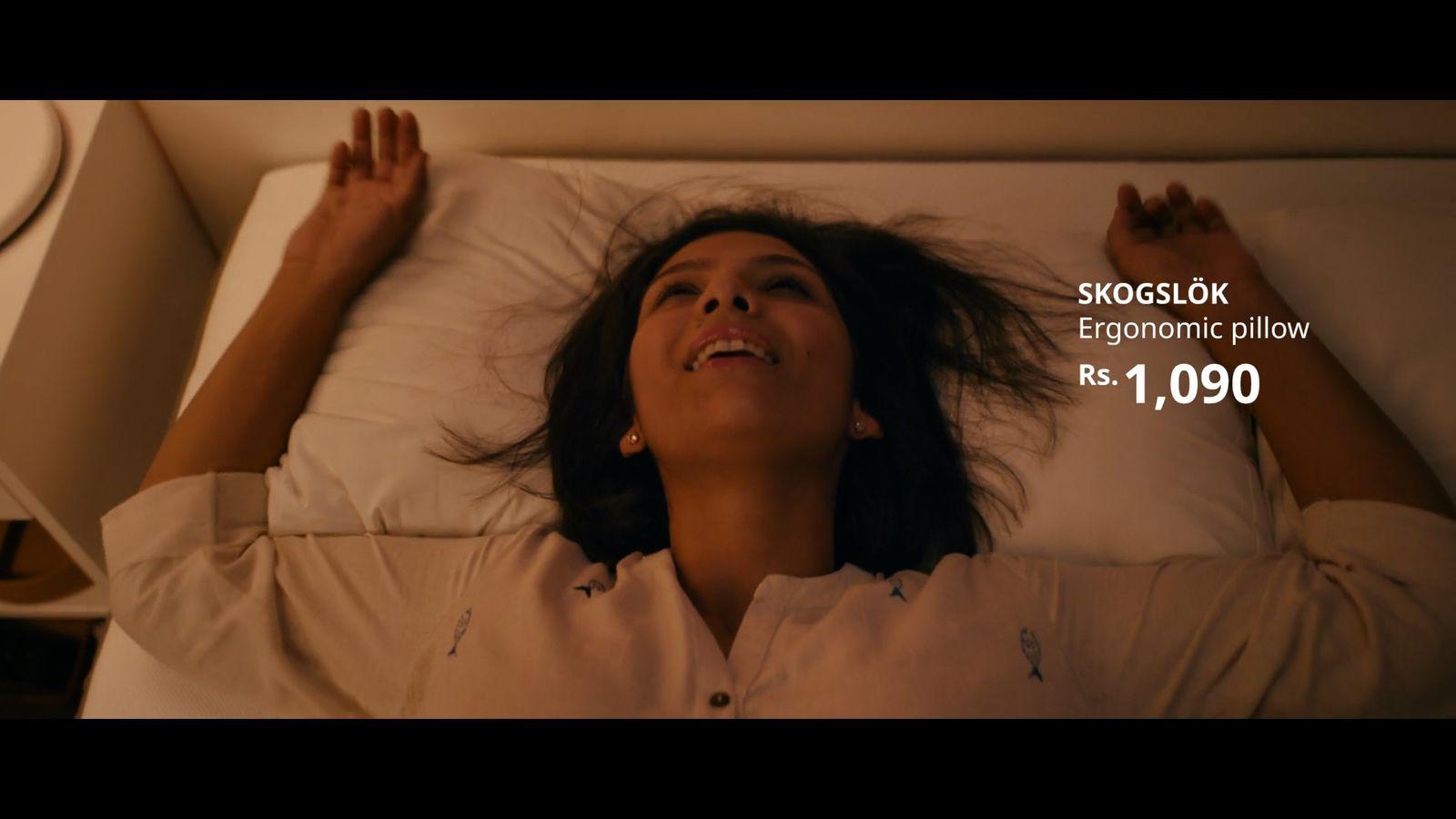 a woman laying in a bed with a pillow