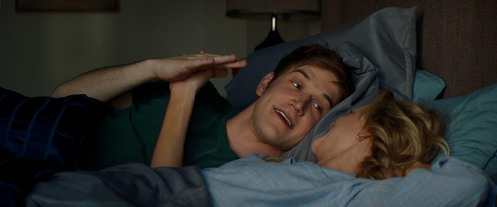 a man and a woman laying in bed together