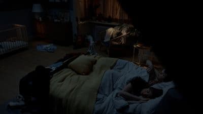 a person laying in a bed in a dark room