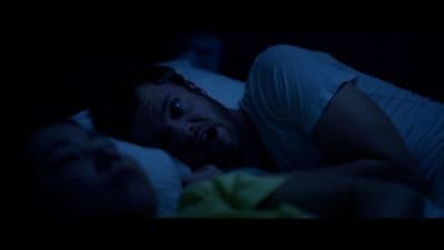 a man laying in bed with his mouth open