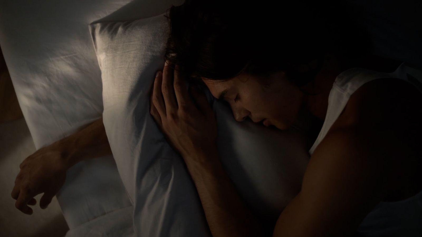 a woman laying in bed with her head on the pillow