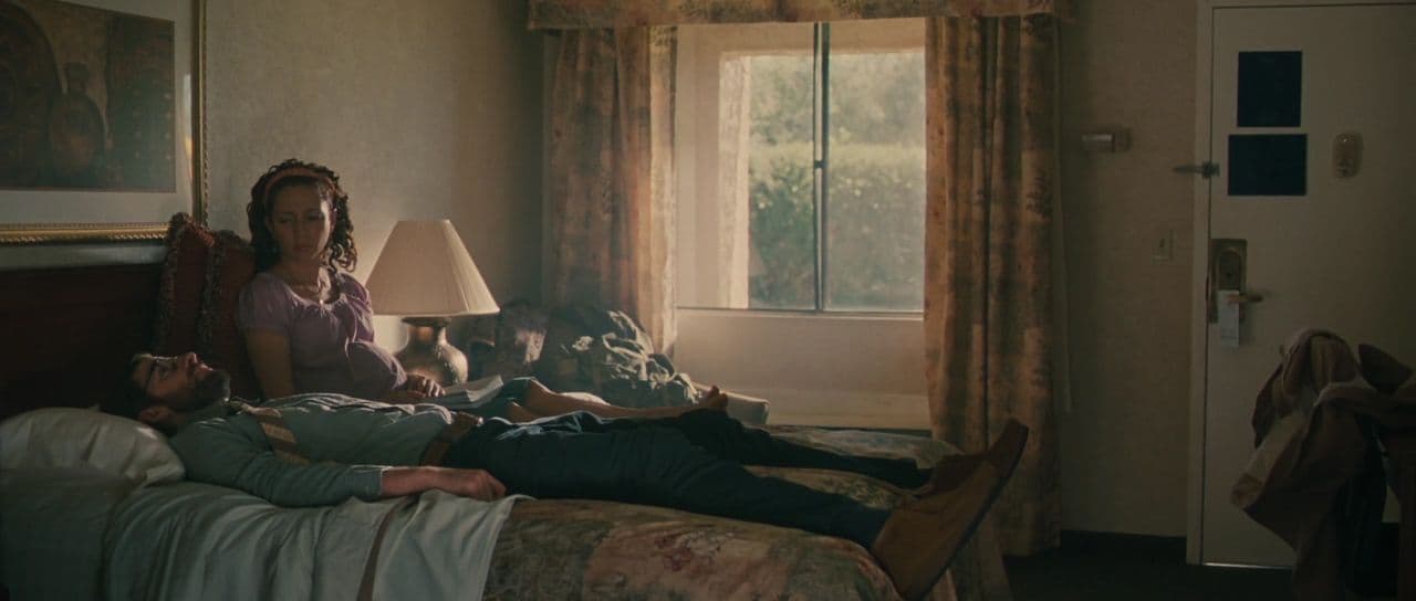 a couple of people laying on top of a bed