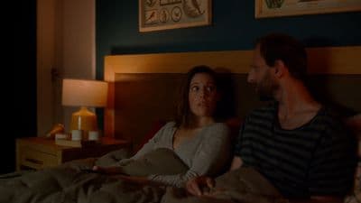 a man and a woman sitting on a bed